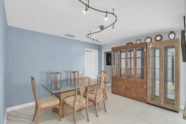 dining space with rail lighting, baseboards, and visible vents