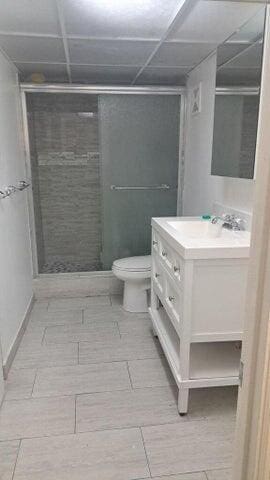 bathroom featuring a stall shower, vanity, and toilet