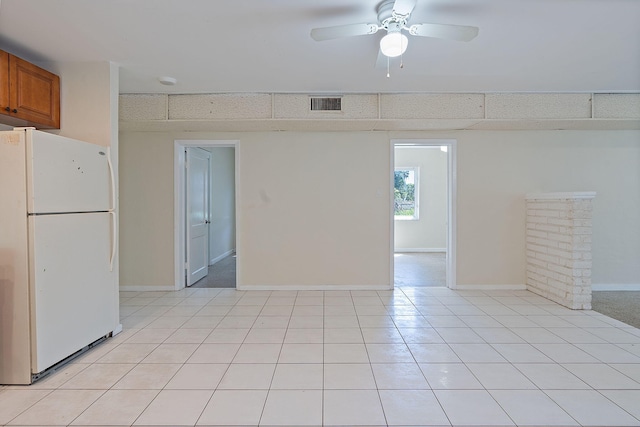 spare room featuring light tile patterned floors, ceiling fan, visible vents, and baseboards