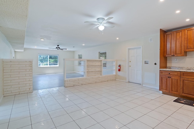 kitchen featuring brown cabinetry, a ceiling fan, recessed lighting, and light tile patterned floors