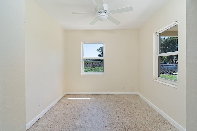 spare room featuring baseboards, a ceiling fan, and speckled floor