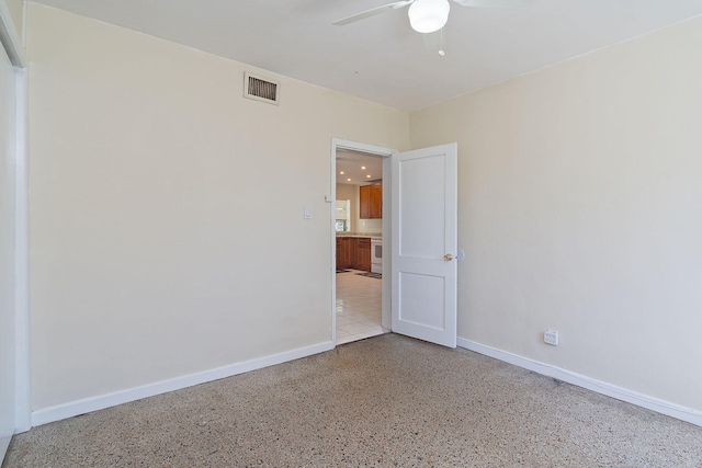 spare room with a ceiling fan, visible vents, and baseboards