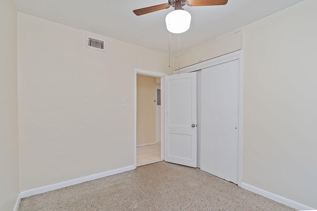 unfurnished bedroom featuring a closet, visible vents, a ceiling fan, baseboards, and speckled floor