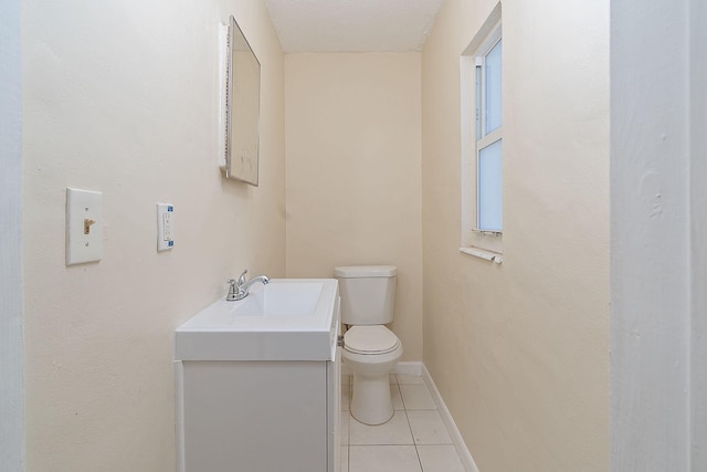 bathroom featuring toilet, vanity, baseboards, and tile patterned floors