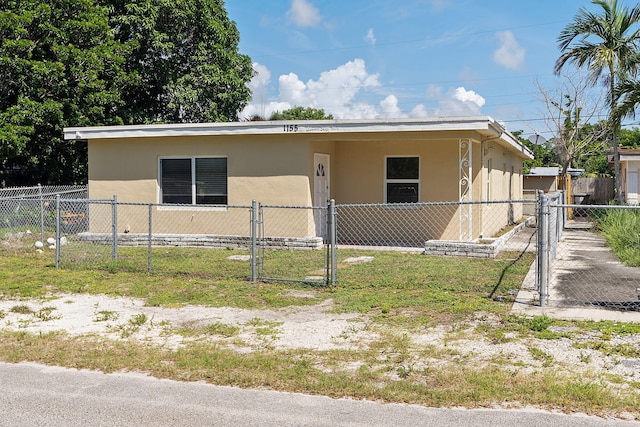 view of front of house with a fenced front yard, a gate, and stucco siding