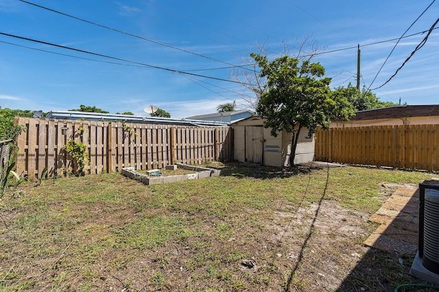 view of yard with a fenced backyard, cooling unit, a storage shed, an outdoor structure, and a vegetable garden