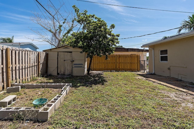 view of yard with a garden, a fenced backyard, a storage unit, and an outdoor structure