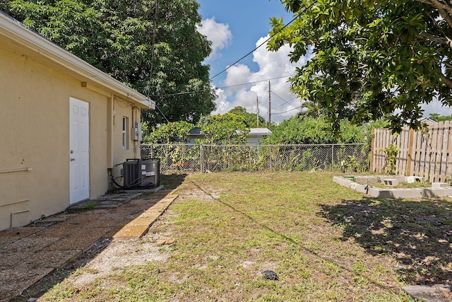 view of yard with central AC unit and fence