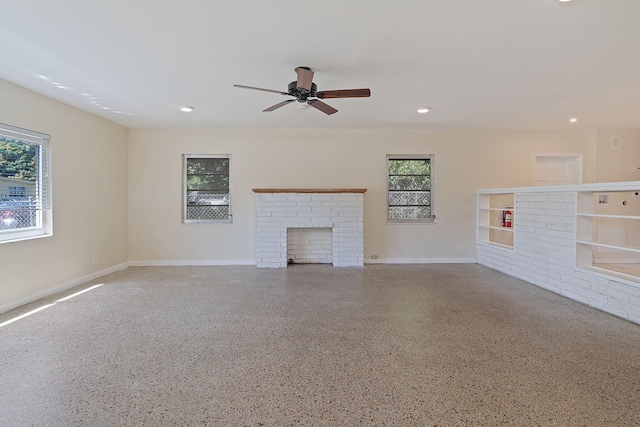 unfurnished living room with recessed lighting, speckled floor, a ceiling fan, baseboards, and a brick fireplace