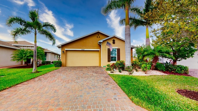 ranch-style home featuring a garage, decorative driveway, a front lawn, and stucco siding