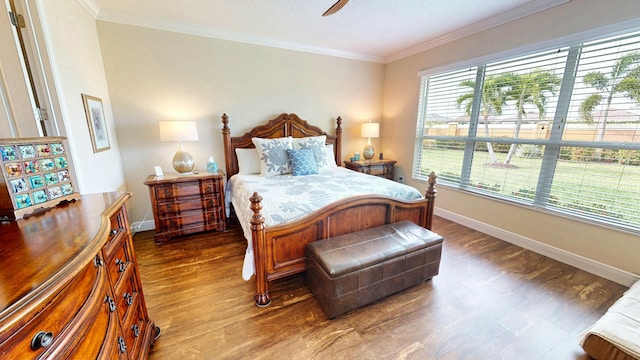 bedroom featuring ornamental molding, dark wood-type flooring, baseboards, and a ceiling fan