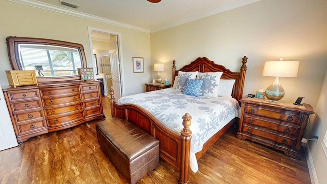 bedroom with ensuite bath, crown molding, visible vents, and wood finished floors