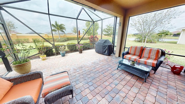 view of patio featuring glass enclosure and area for grilling