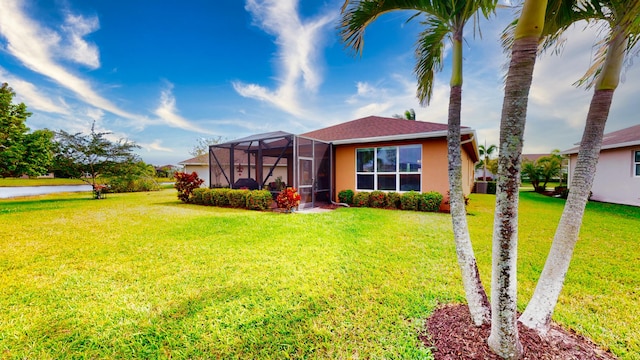 view of front facade with a front lawn, a lanai, and stucco siding