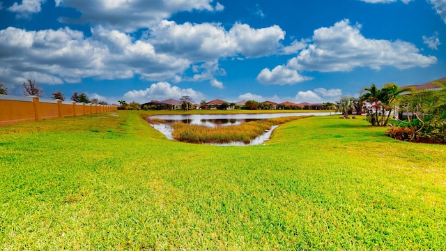 view of yard with a water view, a residential view, and fence