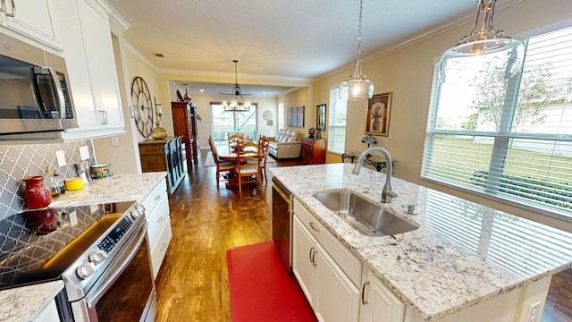 kitchen with stainless steel appliances, dark wood-type flooring, a sink, white cabinets, and tasteful backsplash