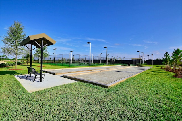 view of property's community with a yard and fence