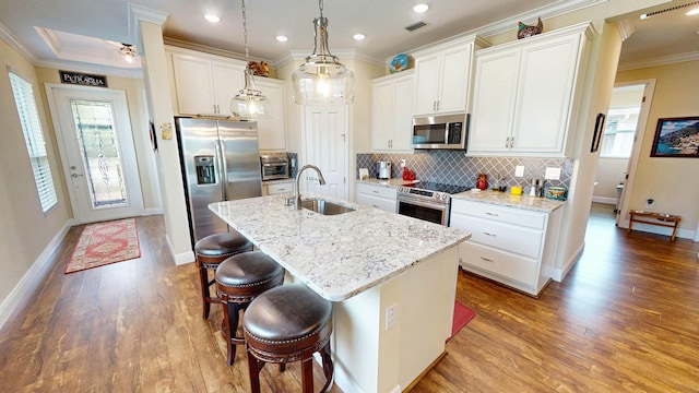 kitchen featuring tasteful backsplash, visible vents, appliances with stainless steel finishes, ornamental molding, and a sink