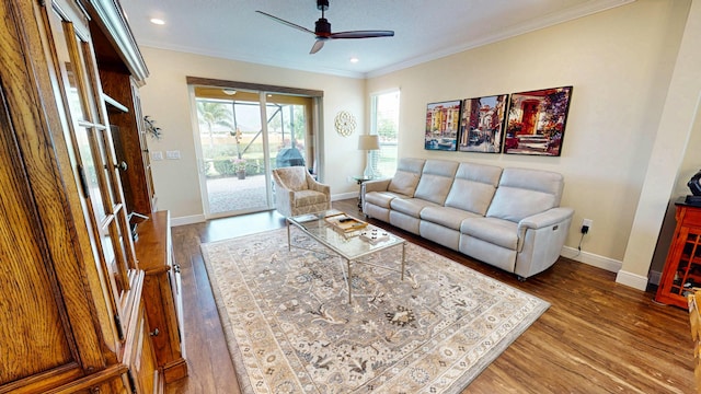 living area featuring baseboards, wood finished floors, and crown molding