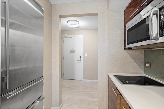 kitchen with stainless steel appliances, light countertops, and decorative backsplash