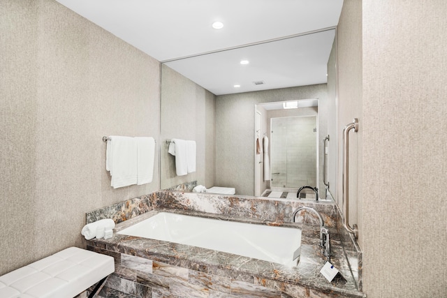 bathroom with a stall shower, a bathing tub, toilet, and recessed lighting