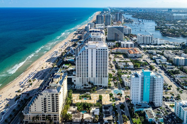 drone / aerial view featuring a view of city, a beach view, and a water view