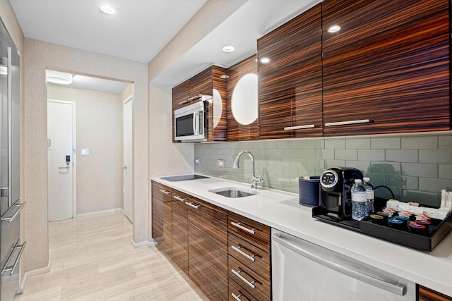 kitchen with light countertops, decorative backsplash, dishwasher, stainless steel microwave, and modern cabinets