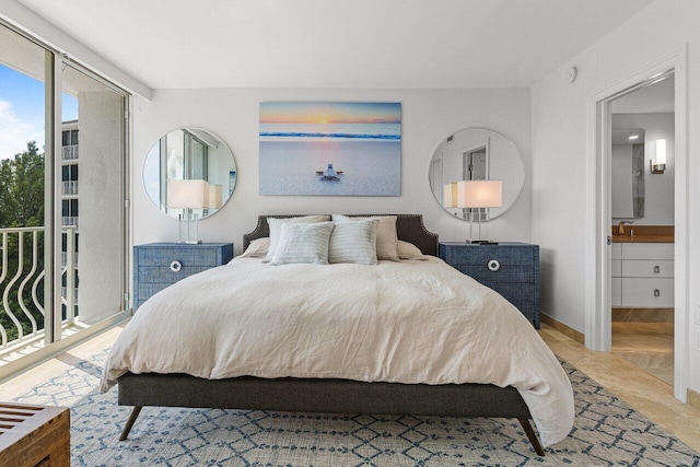 bedroom with access to outside, baseboards, a sink, and ensuite bath