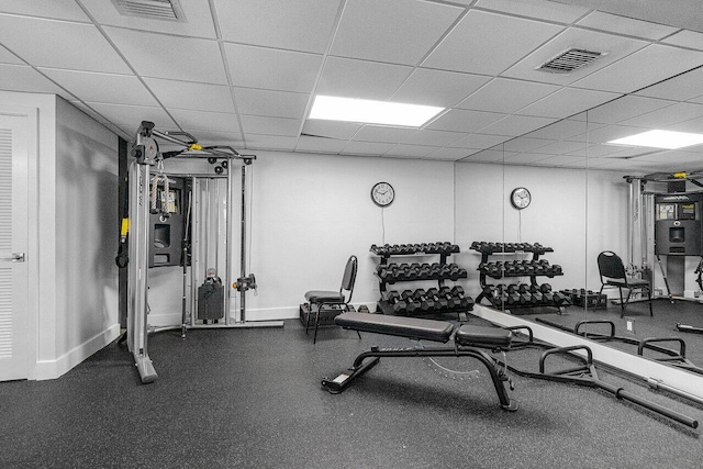 workout area with a paneled ceiling, visible vents, and baseboards