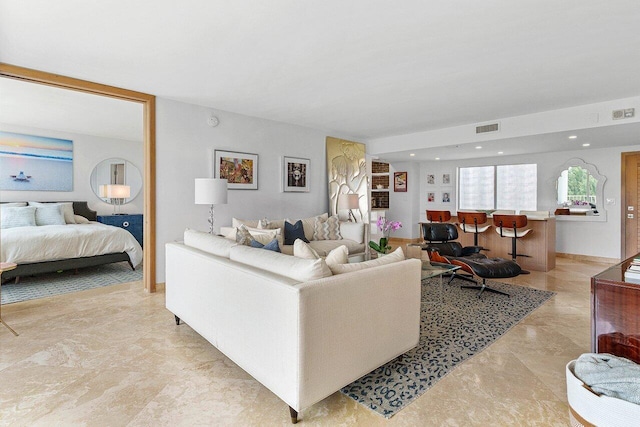 living area featuring recessed lighting, visible vents, and baseboards