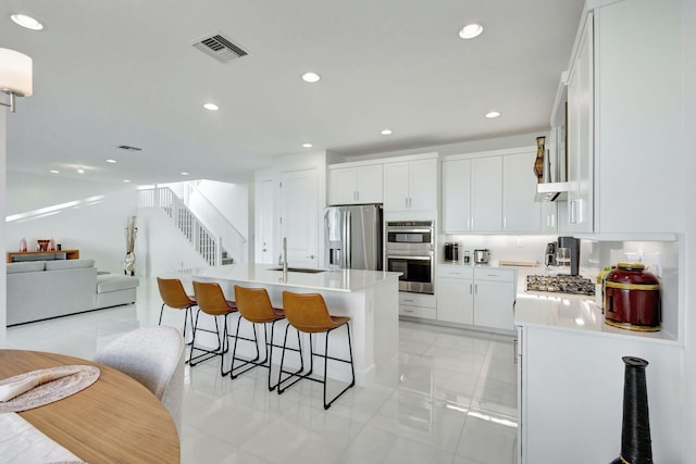1396 Bushel Creek Xing, Loxahatchee, FL 33470 - kitchen with appliances with stainless steel finishes, a sink, a breakfast bar area, light countertops, and recessed lighting