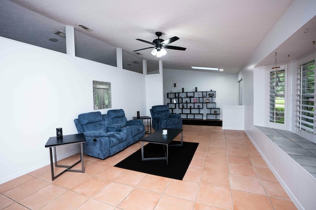 tiled living area with lofted ceiling, ceiling fan, and baseboards