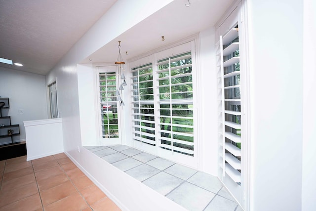hall with tile patterned floors and baseboards