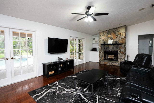 living area featuring french doors, wood finished floors, a ceiling fan, and a fireplace