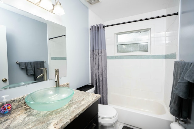 bathroom featuring toilet, shower / bath combo with shower curtain, and vanity