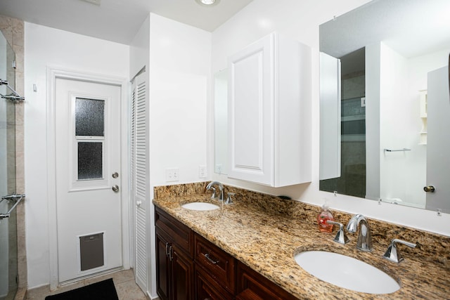 full bathroom featuring double vanity, tile patterned flooring, and tiled shower