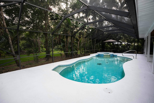 view of pool with a patio area, a pool with connected hot tub, and glass enclosure