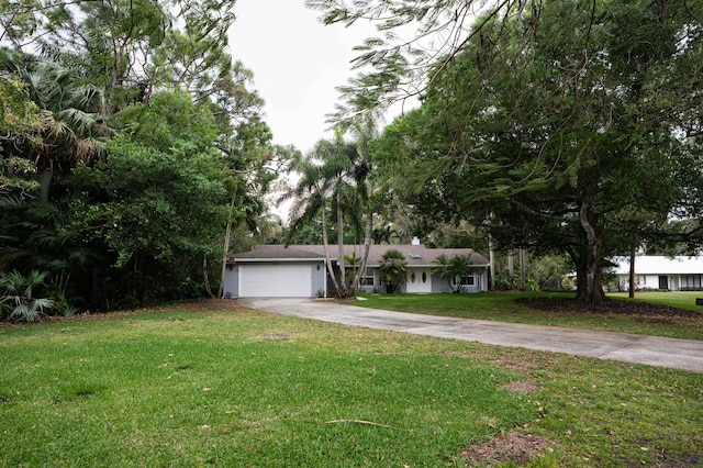 single story home with concrete driveway, an attached garage, and a front lawn