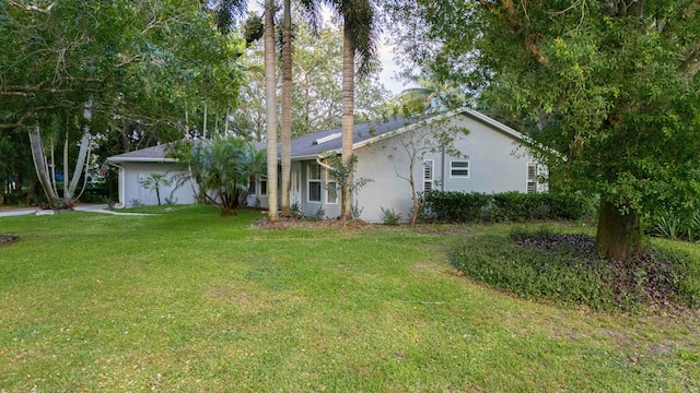 view of front of property featuring a front lawn and stucco siding