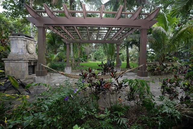 view of patio / terrace featuring an outdoor stone fireplace and a pergola