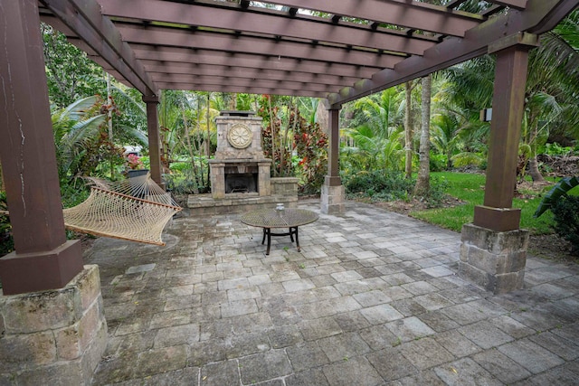 view of patio featuring an outdoor stone fireplace and a pergola