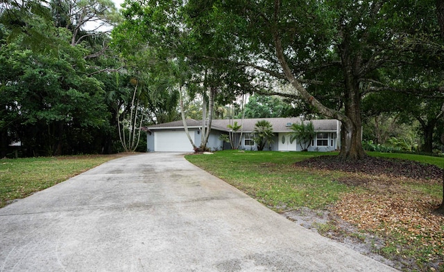 ranch-style home with concrete driveway, a front lawn, and an attached garage