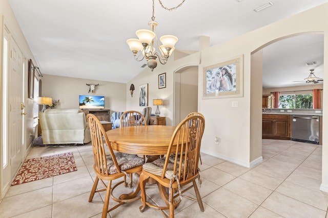 dining area featuring arched walkways, light tile patterned flooring, ceiling fan with notable chandelier, visible vents, and baseboards