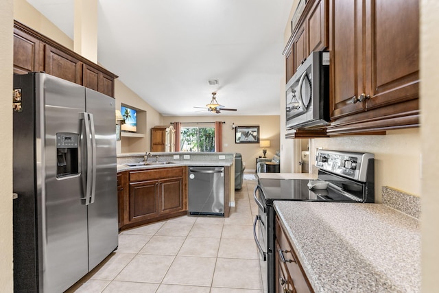 kitchen with light countertops, appliances with stainless steel finishes, light tile patterned flooring, a sink, and a peninsula