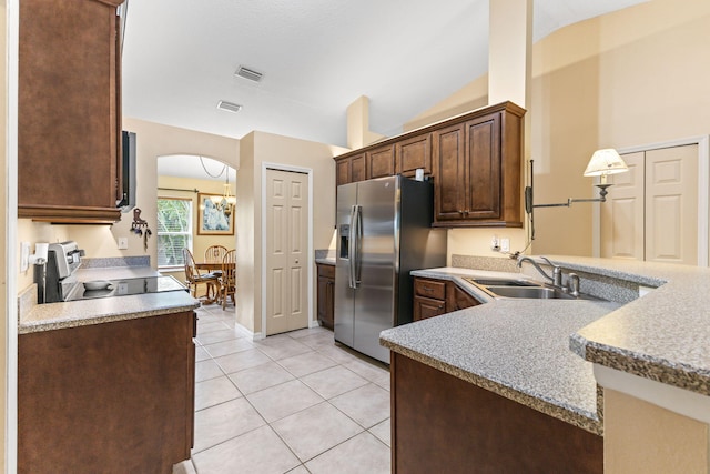 kitchen with light tile patterned floors, a sink, vaulted ceiling, stainless steel refrigerator with ice dispenser, and electric range oven