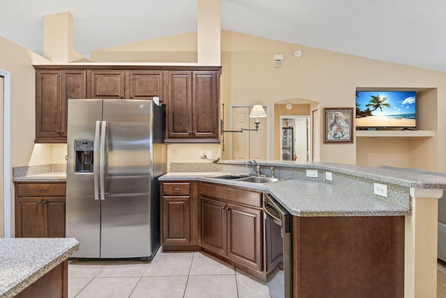 kitchen featuring appliances with stainless steel finishes, vaulted ceiling, a sink, and a peninsula