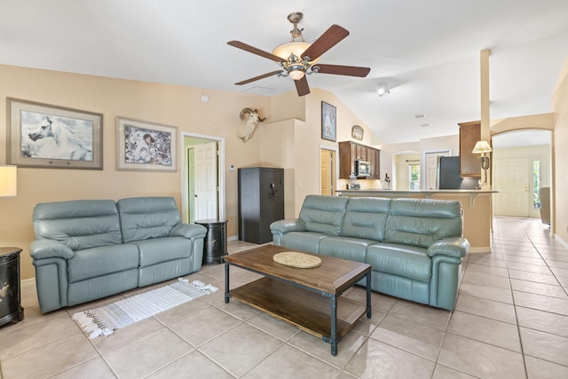 living room with lofted ceiling, light tile patterned floors, arched walkways, and a wealth of natural light