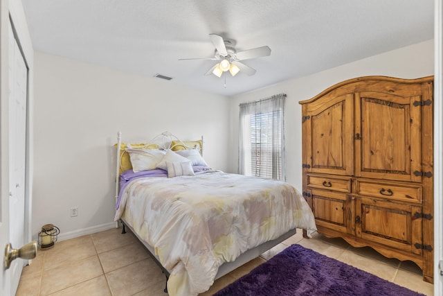 bedroom featuring light tile patterned floors, visible vents, baseboards, and ceiling fan