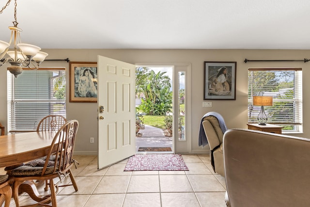 foyer entrance with light tile patterned floors, baseboards, and a notable chandelier