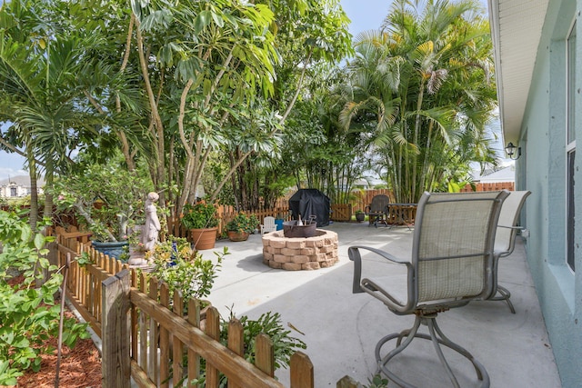 view of patio with an outdoor fire pit, a fenced backyard, and a grill